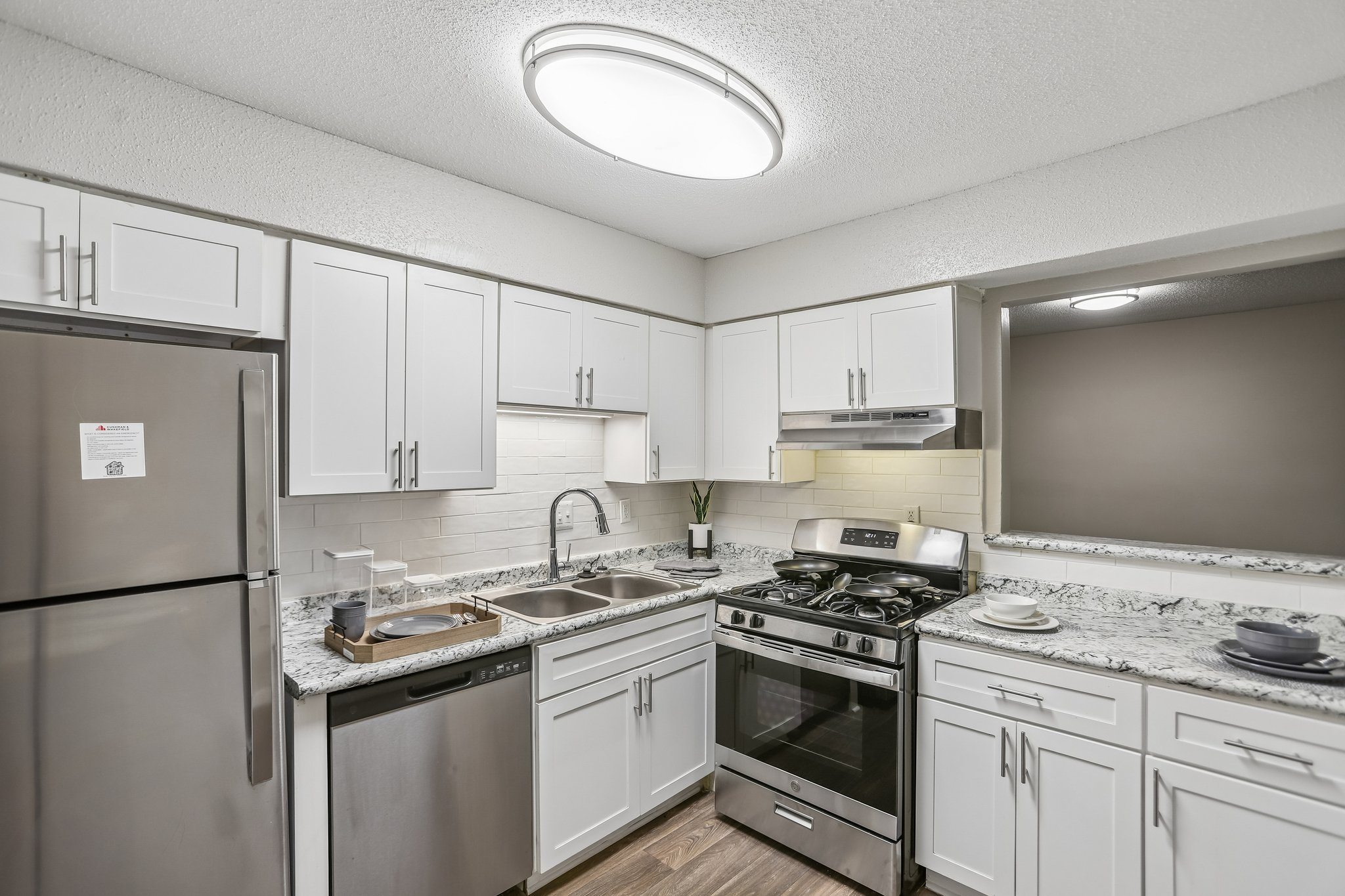 A kitchen with a refrigerator, stove, and sink.